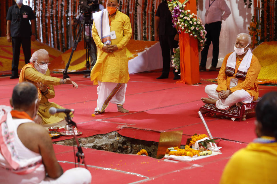 Indian Prime Minister Narendra Modi performs the groundbreaking ceremony of a temple dedicated to the Hindu god Ram, watched by Rashtriya Swayamsevak Sangh (RSS) chief Mohan Bhagwat, seated right, in Ayodhya, India, Wednesday, Aug. 5, 2020. The coronavirus is restricting a large crowd, but Hindus were joyful before Prime Minister Narendra Modi breaks ground Wednesday on a long-awaited temple of their most revered god Ram at the site of a demolished 16th century mosque in northern India. (AP Photo/Rajesh Kumar Singh)