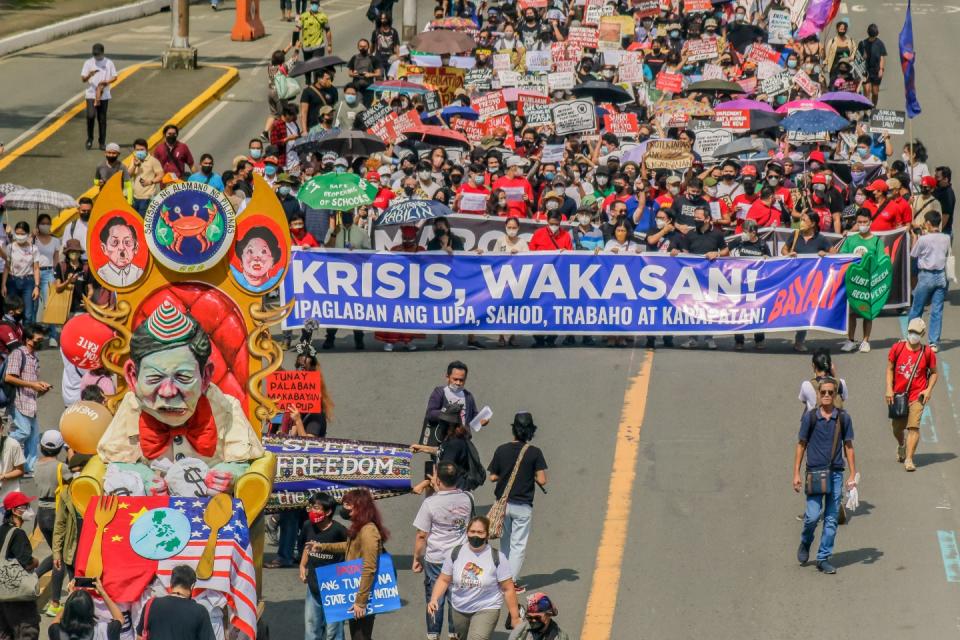 Protesters including farmers march through the street while holding placards and a banner during the demonstration before the first State Of The Nation Address (SONA) of Philippine President Ferdinand Marcos Jr.