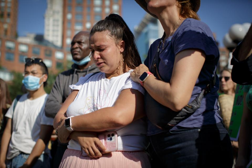 A protester places her hand on the woman standing next to her.