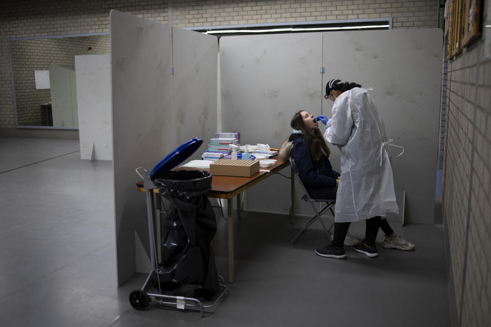 Residents of Bergschenhoek, Netherlands, take part in a mass test of all of the municipality's 62,000 residents starting Wednesday, Jan. 13, 2021, following a cluster of COVID-19 cases at an elementary school, including about 30 cases of the British coronavirus variant. (AP Photo/Peter Dejong)