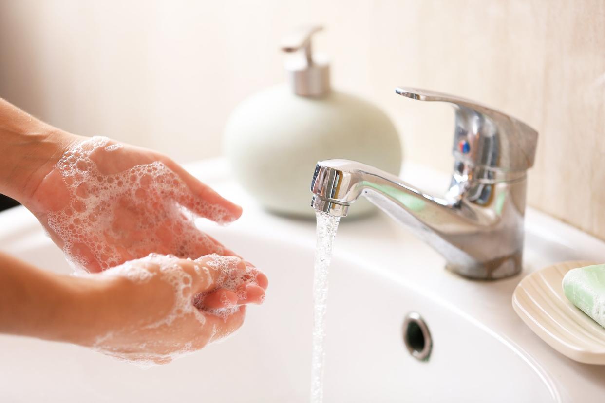 child washing hands in sink