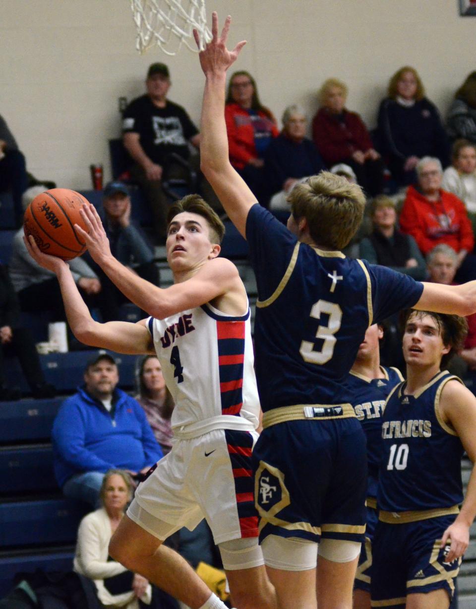 Boyne City's Mason Wilcox (left) drives into the paint in the first half against St. Francis' Drew Breimayer.
