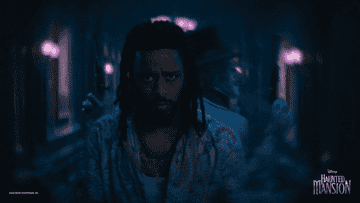 LaKeith Stanfield with two ghosts behind him in Haunted Mansion