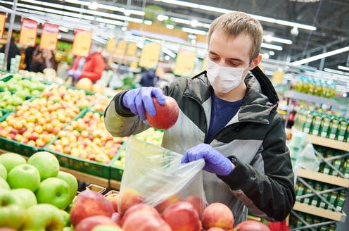 <span class="caption">Take steps to protect yourself while shopping.</span> <span class="attribution"><a class="link " href="https://www.shutterstock.com/image-photo/man-mask-protective-gloves-buying-food-1696298536" rel="nofollow noopener" target="_blank" data-ylk="slk:Dmitry Kalinovsky/ Shutterstock;elm:context_link;itc:0;sec:content-canvas">Dmitry Kalinovsky/ Shutterstock</a></span>