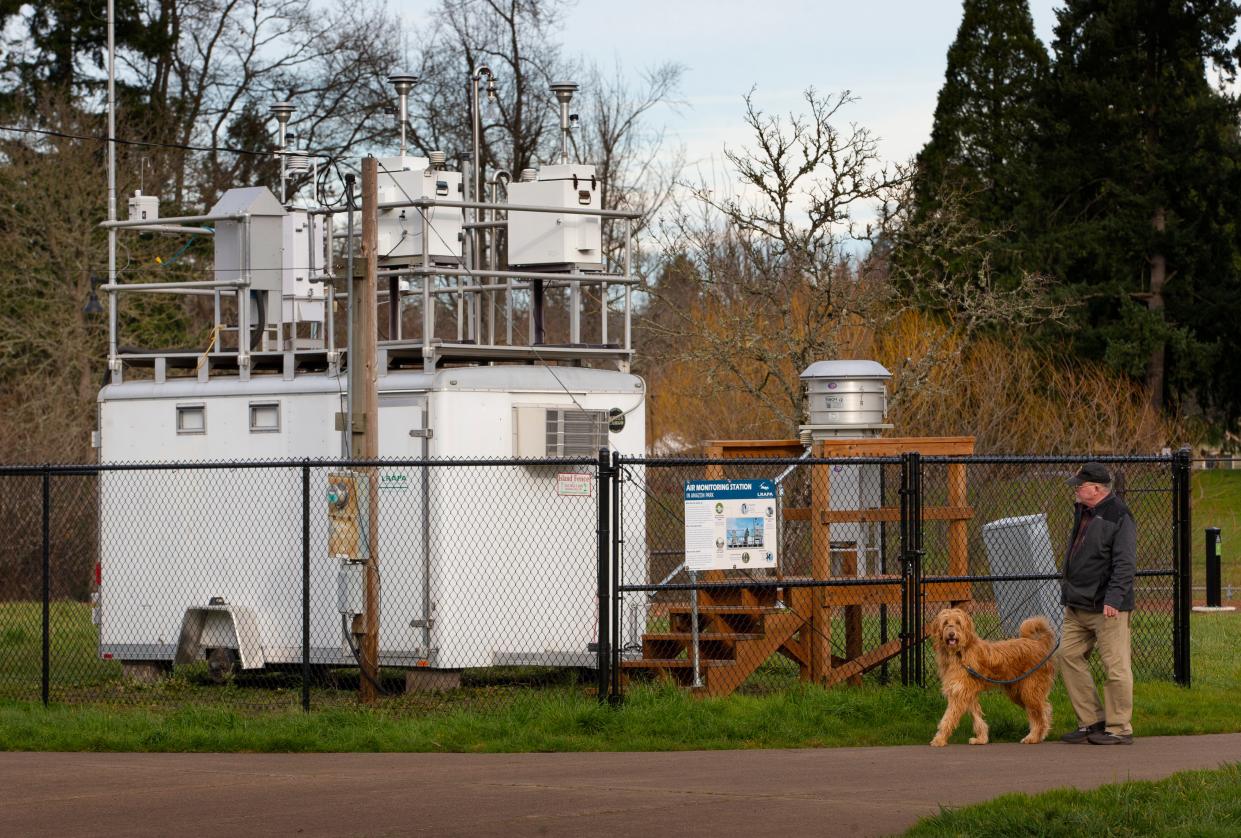 In this file photo, a dog walker strides past an air quality monitor used by Lane Regional Air Protection Agency sits in Amazon Park in Eugene. The air quality monitor now has been moved to Oakridge, where it will collect data on wildfire and wood stove smoke.