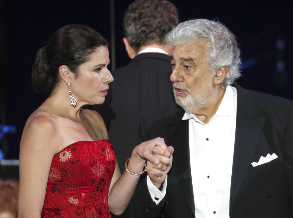 Opera star Placido Domingo holds the hand of Ana Maria Martinez at the end of a concert in Szeged, Hungary, Wednesday, Aug. 28, 2019. Domingo continued his calendar of European engagements unabated despite allegations of sexual harassment, appearing Wednesday at a concert in southern Hungary to inaugurate a sports complex for a local Catholic diocese.(AP Photo/Laszlo Balogh)