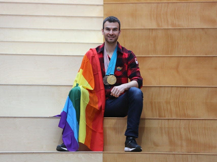 Eric Radford with his Olympic medals and a pride flag