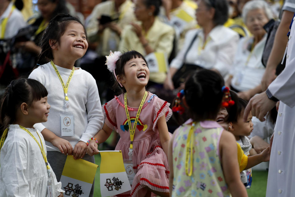 Children play with a priest before the arrival of Pope Francis at Saint Louis Hospital in Bangkok, Thailand, Thursday, Nov. 21, 2019. Pope Francis called for migrants to be welcomed and for women and children to be protected from exploitation, abuse and enslavement as he began a busy two days of activities in Thailand on Thursday. (AP Photo/Manish Swarup)