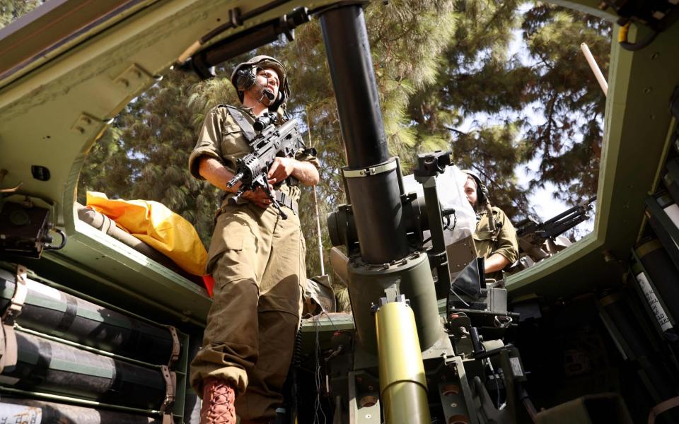 An Israeli soldier stands in an armoured vehicle. The army has yet to be given the order for a full ground invasion