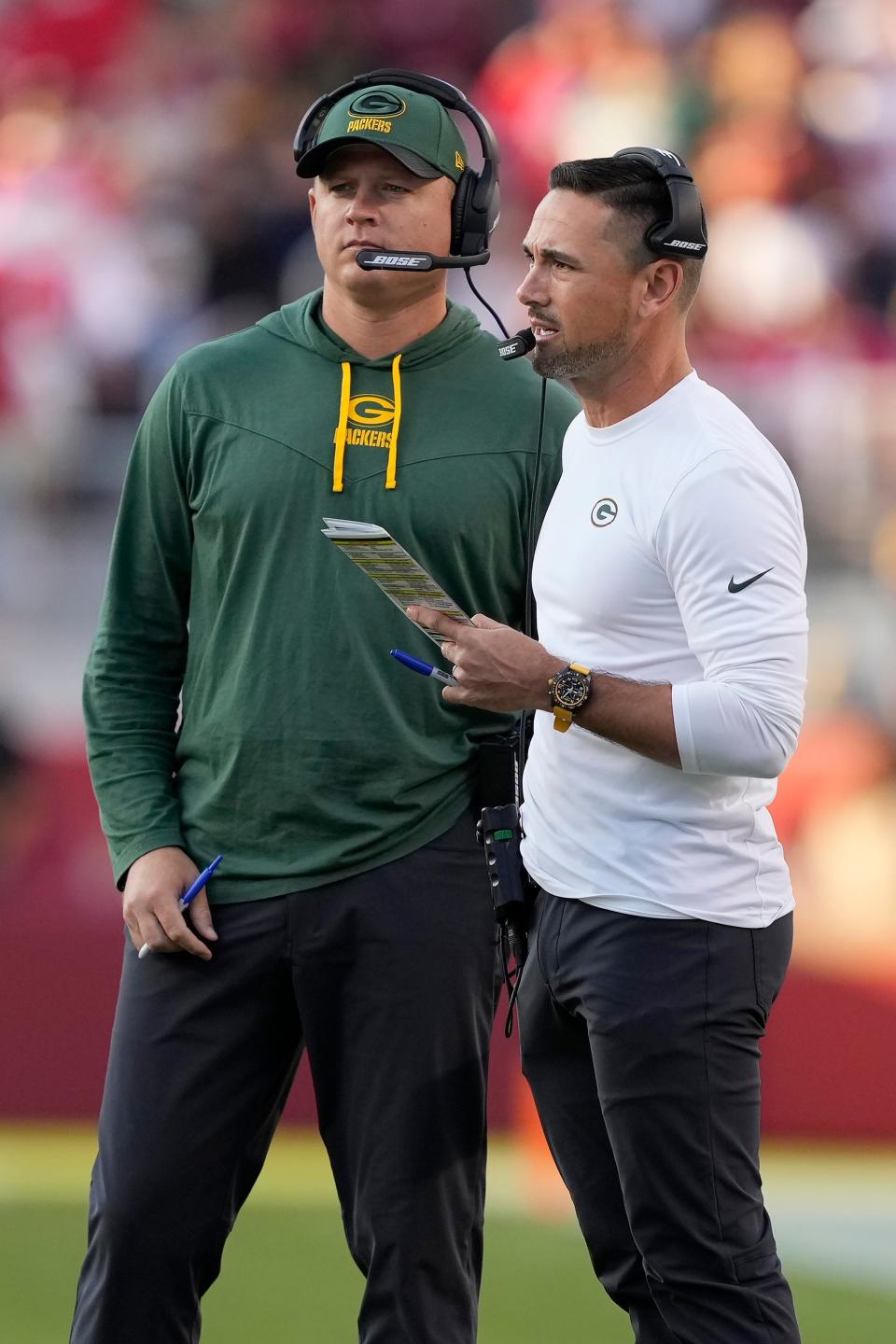 Former Green Bay Packers quarterbacks/passing game coordinator Luke Getsy, left, talks with coach Matt LaFleur during a game this season. [Tony Avelar/Associated Press]