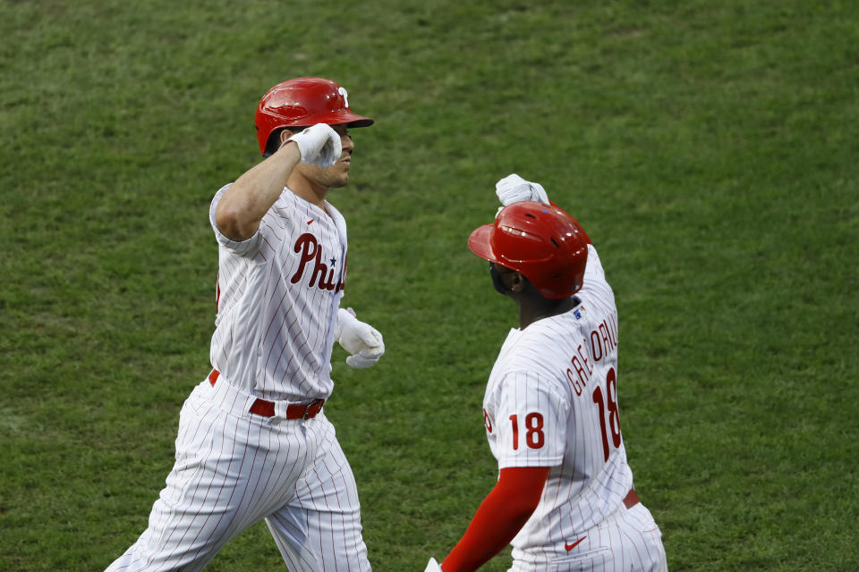 Philadelphia Phillies' J.T. Realmuto, left, and Didi Gregorius celebrate after Realmuto's home run off Atlanta Braves starting pitcher Kyle Wright during the fourth inning of a baseball game, Saturday, Aug. 8, 2020, in Philadelphia. (AP Photo/Matt Slocum)