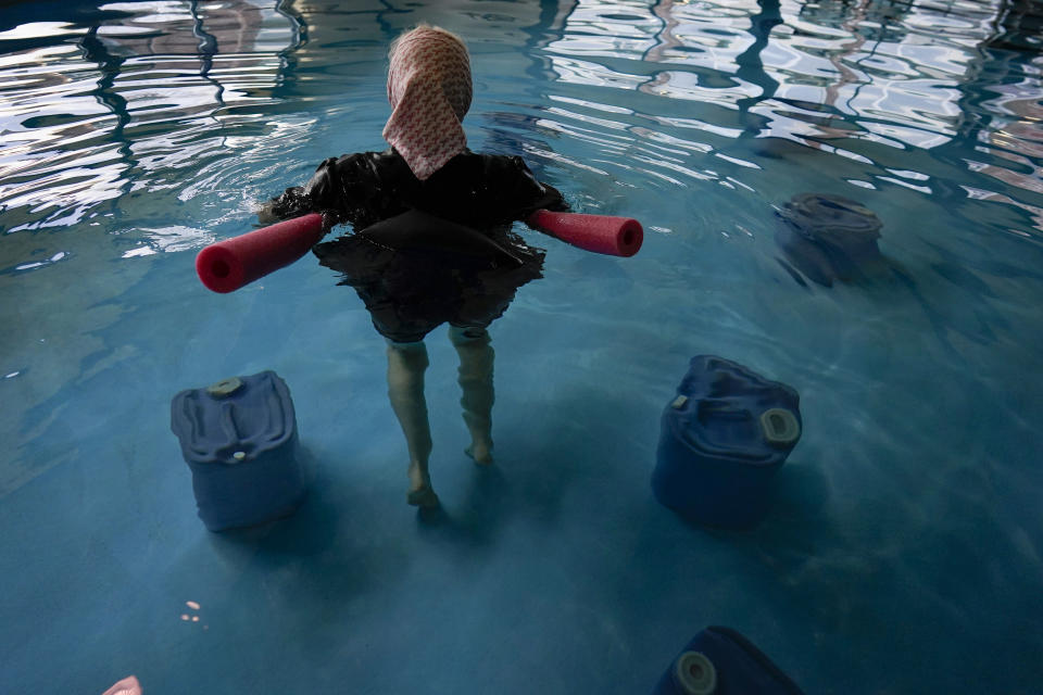 Una mujer amish oriunda de Ohio flota en una piscina entre los generadores "biosanadores" del Tesla Wellness Hotel and MedBed Center, el miércoles 15 de noviembre de 2023, en Butler, Pensilvania. (AP Foto/Carolyn Kaster)