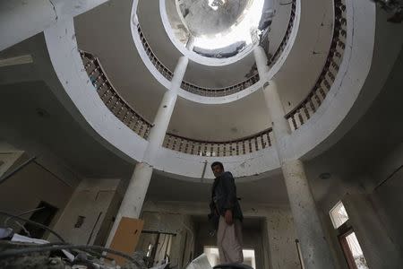 A Houthi militant looks on as he walks inside a government compound, destroyed by recent Saudi-led air strikes, in Yemen's northwestern city of Amran July 27, 2015. REUTERS/Khaled Abdullah