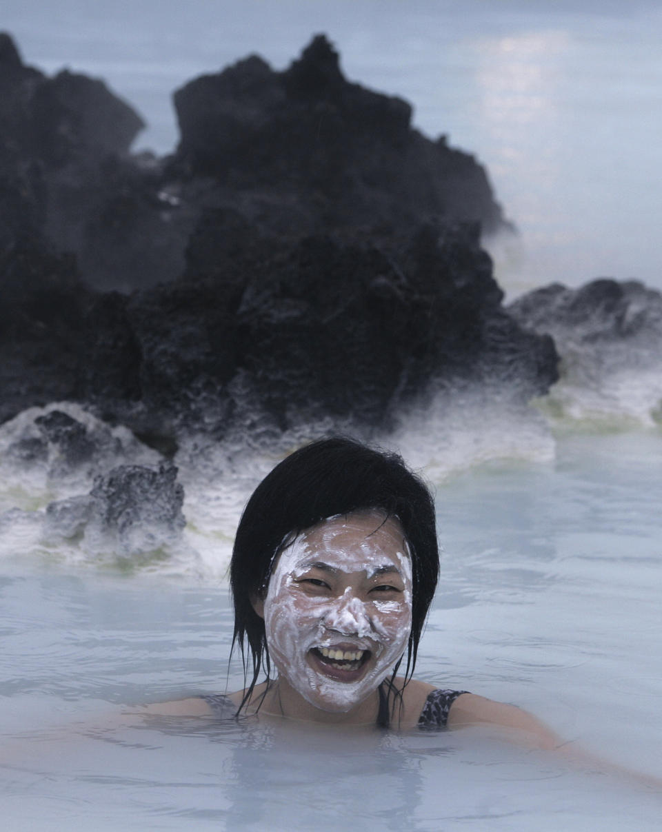 File- A tourist tries a silica face mask in the Blue Lagoon geothermal spa, Iceland, Feb. 21, 2006. The geothermal spa Blue Lagoon has temporarily closed after a series of earthquakes have put Iceland's southwestern corner on volcanic alert, reaching a state of panic on Thursday when a magnitude 5.0 earthquake occurred just after midnight. (AP Photo/Kirsty Wigglesworth, File)