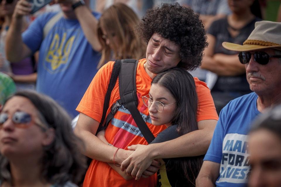 Carlos Rodriguez, Parkland, weeps in the arms of Camila Cortes, Coral Springs, as a speaker recalls the Marjorie Stoneman Douglas High School shooting during a "March for our Lives" event at Pine Trails Park in Parkland on June 11, 2022. They graduated from the school in 2019.