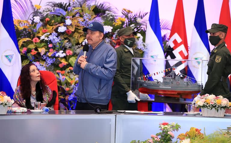 Handout picture released by the Nicaraguan Presidency showing Nicaraguan President Daniel Ortega (2-L) delivering a speech next to Vice-President and First Lady Rosario Murillo during a ceremony marking the 42nd anniversary of the founding of the Nicaraguan Naval Force, in Managua on August 15, 2022. (Photo by Jairo CAJINA / Nicaraguan Presidency / AFP) /