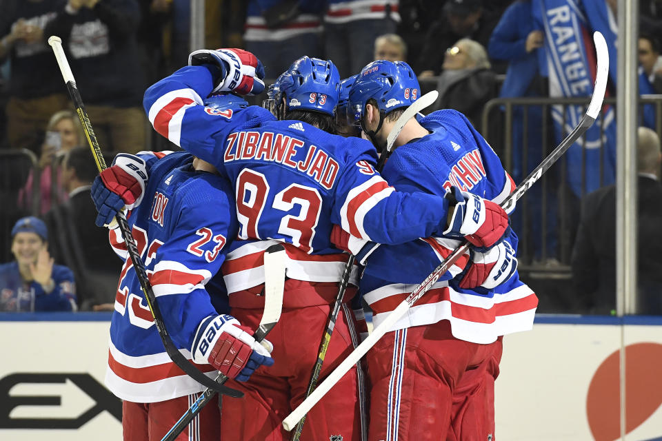 New York Rangers defenseman Adam Fox (23), center Mika Zibanejad (93), and right wing Pavel Buchnevich (89) celebrate a goal by left wing Chris Kreider, obscured, during the second period of the team's NHL hockey game against the Detroit Red Wings, Friday, Jan. 31, 2020, in New York. (AP Photo/Sarah Stier)
