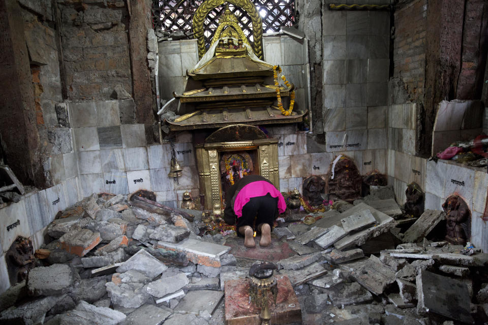 A Hindu Nepalese woman offers prayers at Indrayani temple, that was damaged in Saturday's earthquake, in Kathmandu, Nepal, Monday, April 27, 2015.  (AP Photo/Bernat Armangue)