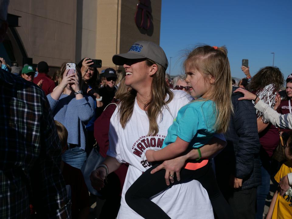 WT volleyball coach Kendra Potts smiles with her daughter after the team returns from winning the National Championship on Monday, Dec. 5, 2022.