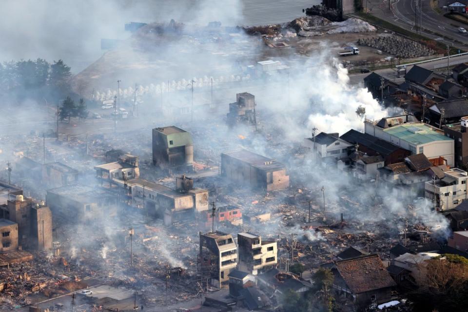 Smoke rise as fire continues after multiple strong earthquakes hit the area on 2 January (The Asahi Shimbun via Getty Imag)