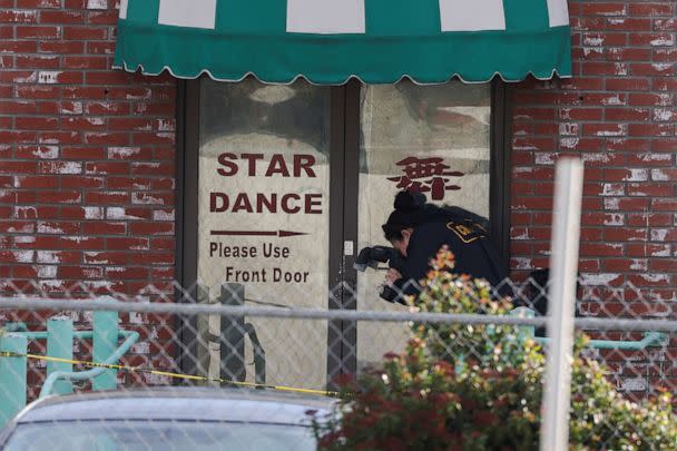 PHOTO: A person from the crime lab takes photographs around the rear entrance of the location of a shooting that took place during a Chinese Lunar New Year celebration, in Monterey Park, Calif., Jan. 22, 2023. (Mike Blake/Reuters)