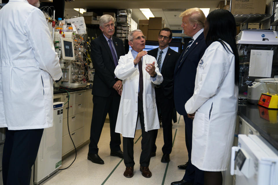 FILE - Dr. Anthony Fauci, director of the National Institute of Allergy and Infectious Diseases, talks with President Donald Trump during a tour of the Viral Pathogenesis Laboratory at the National Institutes of Health, March 3, 2020, in Bethesda, Md. Fauci steps down from a five-decade career in public service at the end of the month, one shaped by the HIV pandemic early on and the COVID-19 pandemic at the end. (AP Photo/Evan Vucci, File)