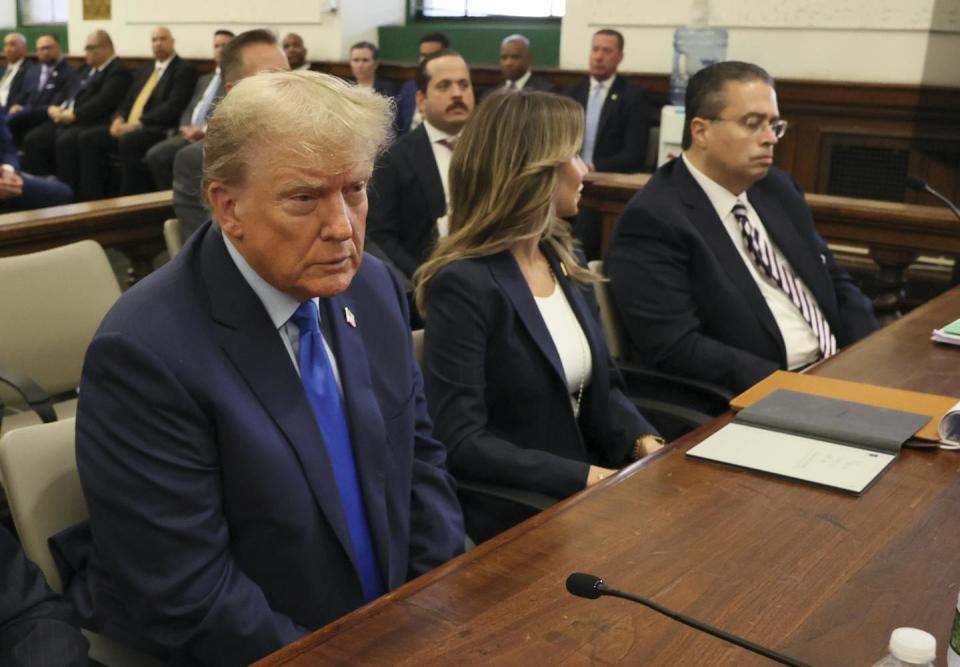 Three people in business suits sit at a table.