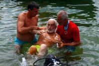 Bulgarian Yane Petkov, 64, is held after he wanted to set a new Guinness World Record by attempting to swim more than three kilometers at Macedonia's Lake Ohrid,Ê in a bag with his arms and legs tied up, in Ohrid, Macedonia July 24, 2018. ÊREUTERS/Ognen Teofilovski