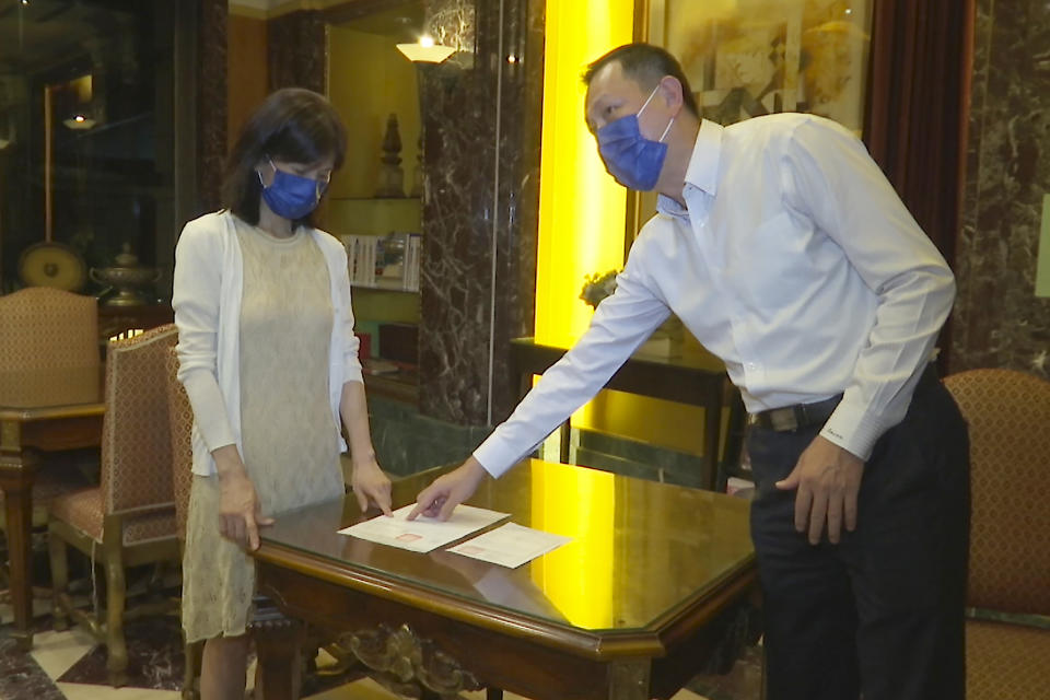 Jason Ding, right and Nancy Chen show the medical record and death certificate of Chen's father on September 16, 2021, in Banqiao district in New Taipei City, Taiwan. The island is hailed globally as a pandemic success story. But for Chen and other families who lost loved ones, they are angry that their government did not prepare enough and they don't believe it's a success. (AP Photo/Johnson Lai)