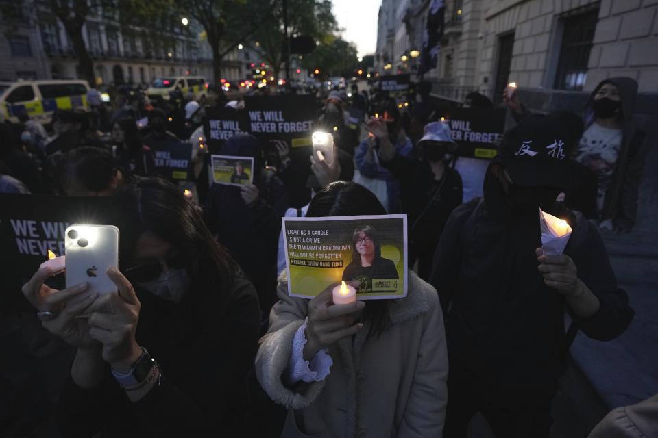 People attend a candlelight vigil outside the Chinese embassy in London, Sunday, June 4, 2023 to mark the anniversary of China's bloody 1989 crackdown on pro-democracy protests in Beijing's Tiananmen Square. (AP Photo/Kin Cheung)