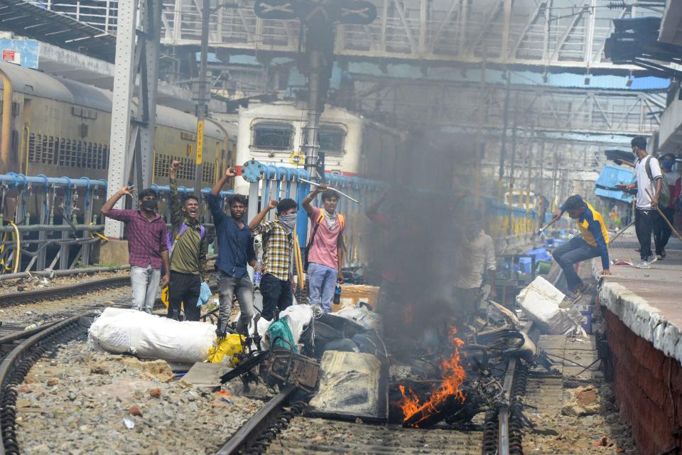 Protestors shout slogans after setting goods and vehicles on fire during a demonstration against the government's new 