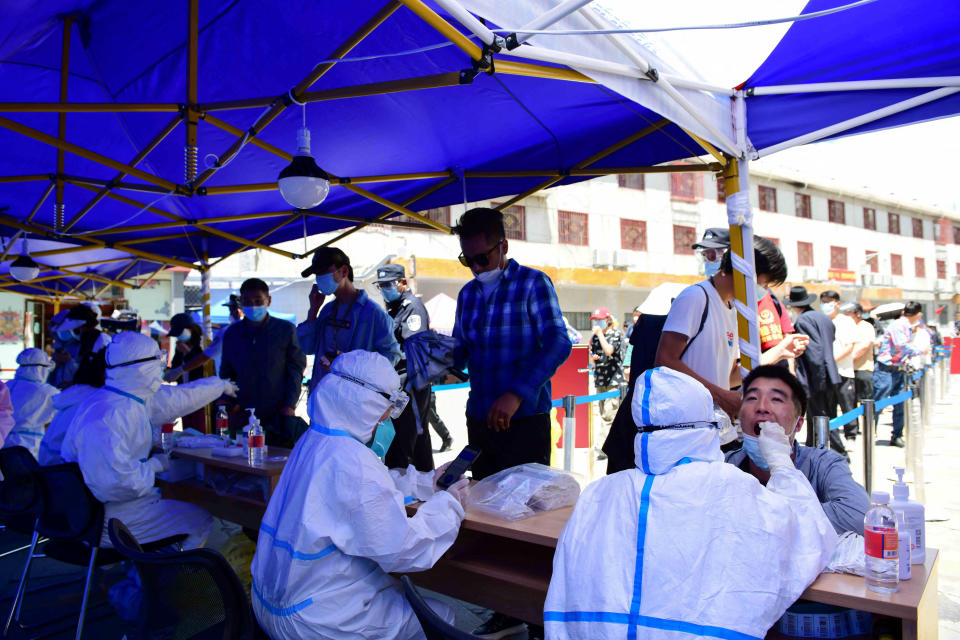 Residents line up to take nucleic acid test during a mass testing following an outbreak of the coronavirus disease (COVID-19), in Lhasa, Tibet Autonomous Region, China August 9, 2022. cnsphoto via REUTERS ATTENTION EDITORS - THIS IMAGE WAS PROVIDED BY A THIRD PARTY. CHINA OUT.