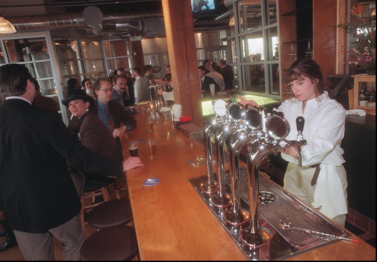 Susanne Fracchia pours beer for a customer at the Empire Brewing Company during the VIP opening party Jan. 13, 1997.