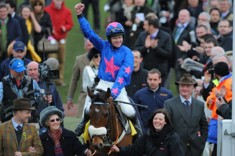 Jockey Joe Tizzard riding Cue Card celebrates after winning the Ryanair Steeple Chase on the third day of the Cheltenham Festival in Gloucestershire, western England on March 14, 2013