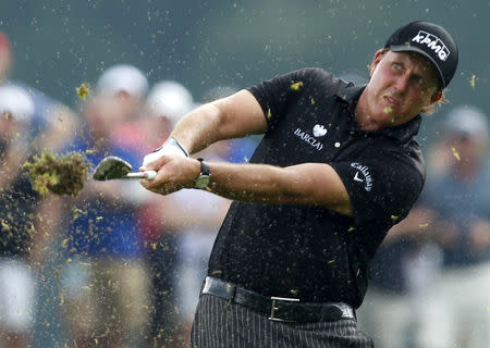 FILE PHOTO: Phil Mickelson of the U.S. hits off a wet fourth fairway during the final round of the 2014 PGA Championship at Valhalla Golf Club in Louisville, Kentucky, August 10, 2014. REUTERS/John Sommers II (UNITED STATES - Tags: SPORT GOLF)