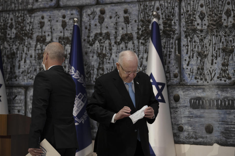 Chairman of Israel's Central Elections Committee Judge Uzi Fogelman, left, leaves the podium after handing the official election results to Israeli President Reuvin Rivlin, right, in Jerusalem, Wednesday, March 31, 2021. (AP Photo/Maya Alleruzzo).