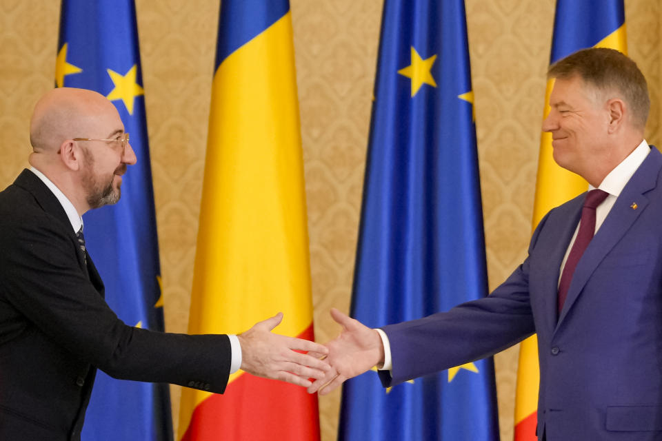 European Council President Charles Michel, left, shakes hands with Romanian President Klaus Iohannis at the end of joint statements at the Cotroceni Presidential Palace in Bucharest, Romania, Monday, March 27, 2023. (AP Photo/Andreea Alexandru)