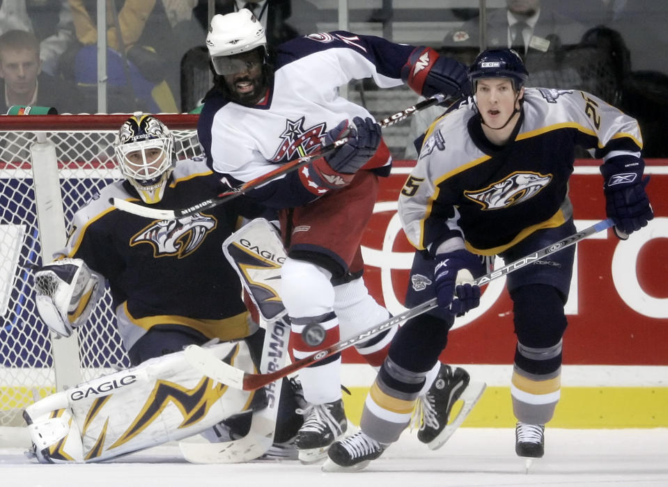 FILE - In this Jan. 12, 2007, file photo, Nashville Predators center Jerred Smithson (25) clears the puck away from Columbus Blue Jackets right wing Anson Carter, center, in the first period of an NHL hockey game in Nashville, Tenn. Carter played a decade in the NHL and has since become an analyst for NBC Sports, which will launch “Hockey Culture” with him at the center of the show. (AP Photo/Mark Humphrey, File)