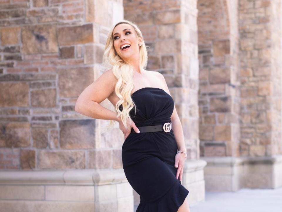 Sarah Juree smiling and posing in a black dress