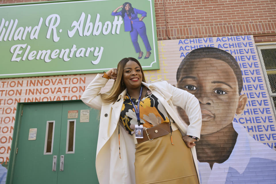 Ava Coleman posing in front of her photo on the abbott elementary sign