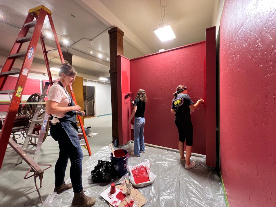 COS Adjunct Professor Amie Rangel, left, works with students Grayce Martin and Denisse Mederos inside CACHE. Students from the Gallery Exhibition class designed and installed "Exeter on Fire," one of four new historical exhibits.