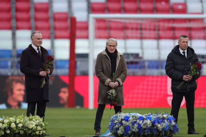Karl-Heinz Rummenigge, Wolfgang Overath and Lothar Matthaeus stand by the wreaths during the memorial service for the late legendary footballer Franz Beckenbauer in the Allianz Arena. Christian Charisius/dpa