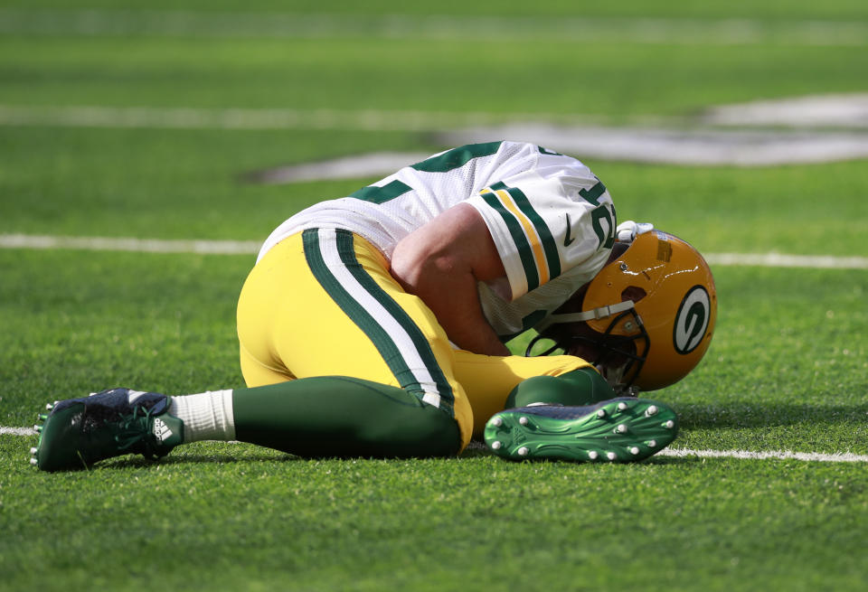 Packers quarterback Aaron Rodgers lies on the ground after being hit by Vikings outside linebacker Anthony Barr. (AP)