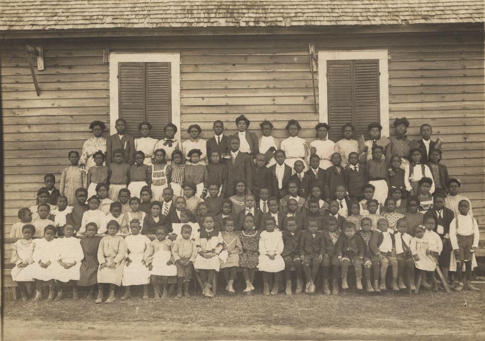 A teacher and his pupils outside their one-room school house in Lowndes County, Alabama in the 1910s. The teacher taught all the students pictured here, regardless of grade. Jim Crow laws and disenfranchisement led to severe underfunding of Black public schools.