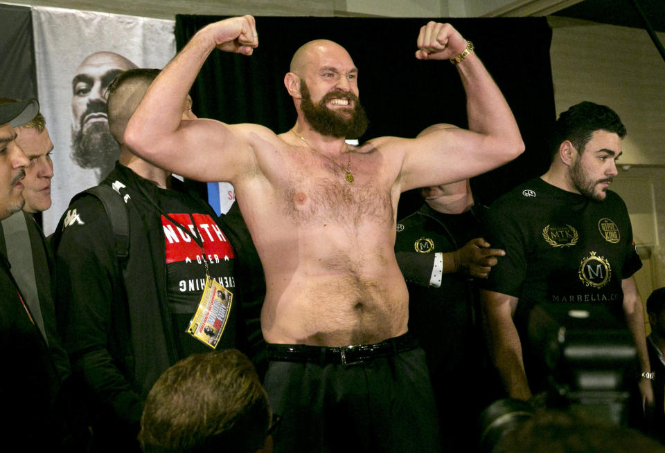 Boxer Tyson Fury flexes after exchanging words with opponent Deontay Wilder at a news conference in Los Angeles, Wednesday, Nov. 28, 2018, ahead of their heavyweight world championship boxing match at Staples Center, on Dec. 1. (AP Photo/Damian Dovarganes)