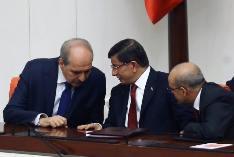 Turkish Prime Minister Ahmet Davutoglu (C) huddles with deputy prime ministers Numar Kurtulmus (L) and Mehmet Simsek (R) on November 25, 2015, as tensions soared in the wake of Turkey's downing of a Russian warplane November 24