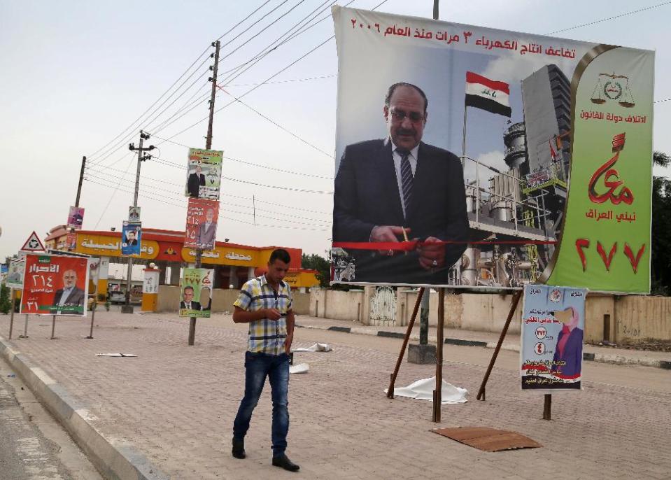 FILE - In this file photo taken on April 27, 2014 a man passes by a campaign poster of Iraqi Prime Minister Nouri al-Maliki in Basra, Iraq's second-largest city, 340 miles (550 kilometers) southeast of Baghdad, Iraq. If Iraqi Prime Minister Nouri al-Maliki wins a third four-year term in parliamentary elections Wednesday, he is likely to rely on a narrow sectarian Shiite base, only fueling divisions as Iraq slides deeper into bloody Shiite-Sunni hatreds. (AP Photo/ Nabil al-Jurani, File)