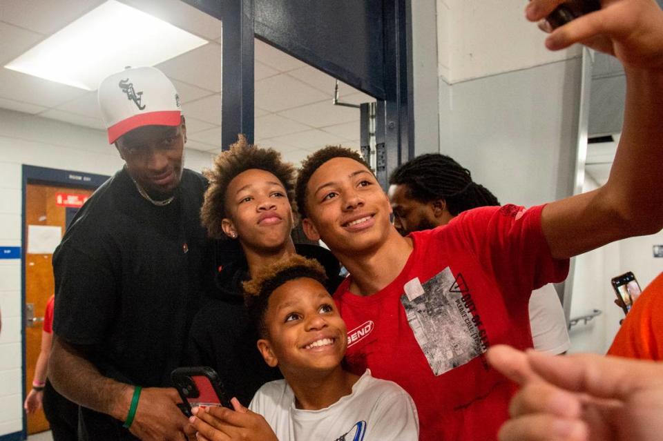 Phoenix Suns player Torrey Craig poses for a photo with Moss Point students following a ceremony for the retirement of his teammate Devin Booker’s high school jersey at Moss Point High School in Moss Point on Saturday, Dec. 10, 2022.