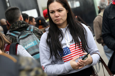 A Venezuelan migrant wearing a T-shirt with the American flag stands outside the Interpol headquarters, in Lima, Peru August 16, 2018. REUTERS/Mariana Bazo