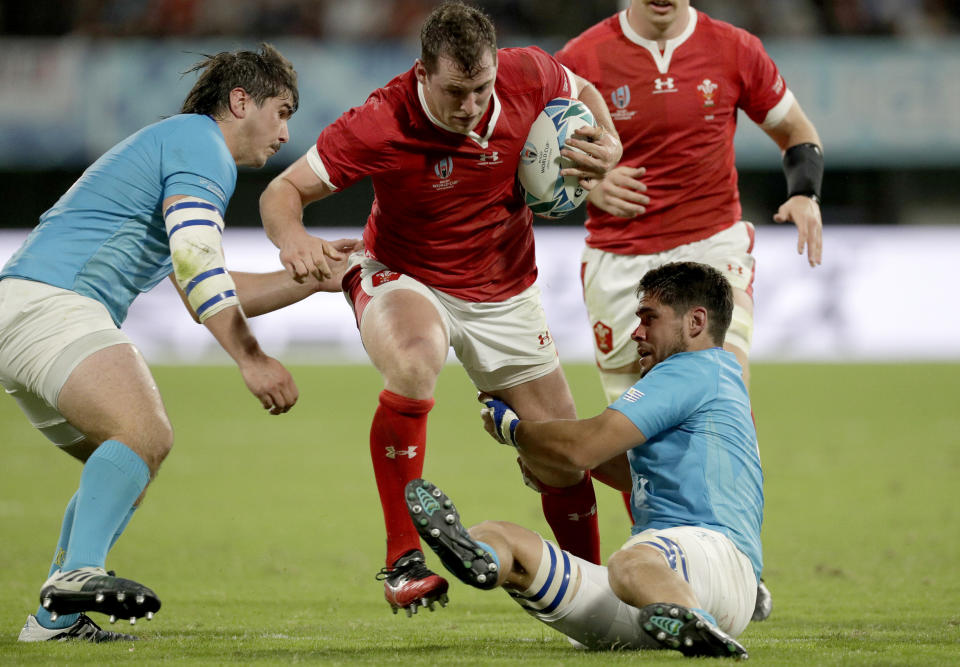 Wales' Ryan Elias is tackled by Uruguayan defenders during the Rugby World Cup Pool D game at Kumamoto Stadium between Wales and Uruguay in Kumamoto, Japan, Sunday, Oct. 13, 2019. (AP Photo/Aaron Favila)